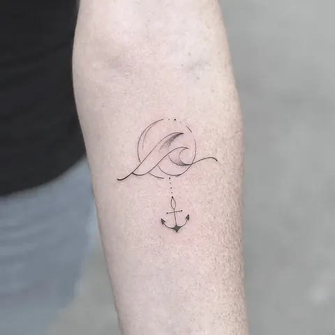 Fineline tattoo of a wave and an anchor on the inside of the upper arm