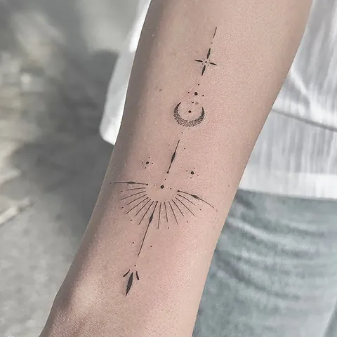 Close-up of a fineline ornament with sun rays and an arrow on the forearm