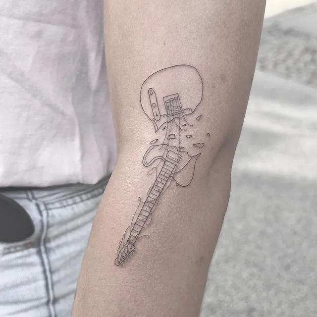 Fineline tatovering af guitar på arm