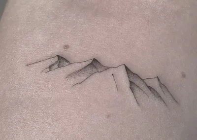 Fineline tatovering af bjergkæde med skygger på ryggen