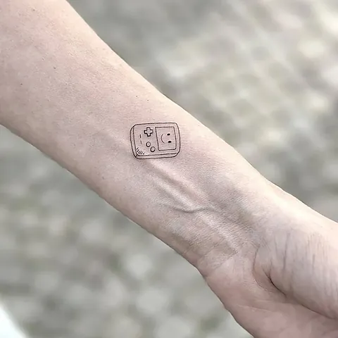 Fineline tatovering af håndholdt spillekonsol på håndled