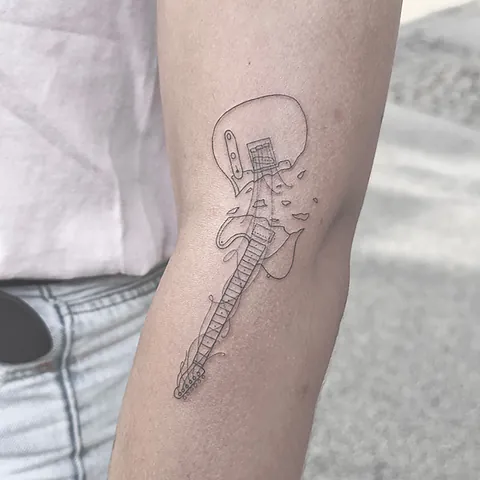 Fineline tatovering af guitar med detaljer på arm