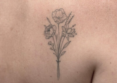 Helet fineline tatovering af blomsterbuket på skulder