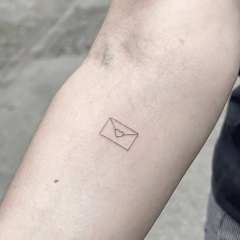 Fineline tattoo of a sealed envelope on the forearm