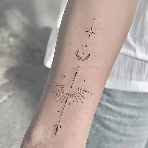 Fineline ornament with a crescent moon, sun rays and an arrow down the forearm