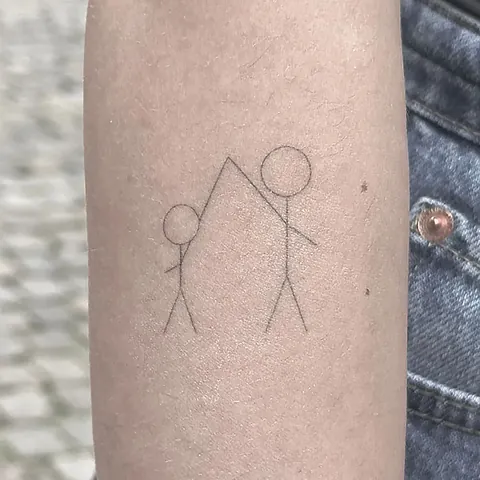 Fineline tattoo of two stick figures holding hands