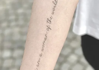 Fineline tatovering med håndskrevet engelsk sætning langs underarmen