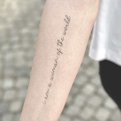 Fineline tatovering med håndskrevet engelsk sætning langs underarmen