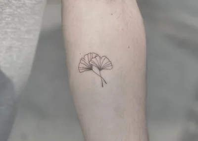 Fineline-tatovering af et ginkgoblad på underarmen