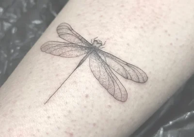 Detaljeret fineline-tatovering af en guldsmed