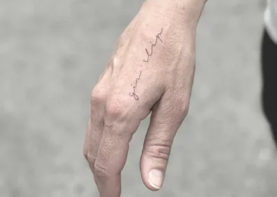Fineline-tatovering med håndskrift på hånden