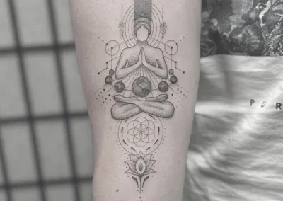 Fineline-tatovering af en mediterende figur med geometriske former på underarmen