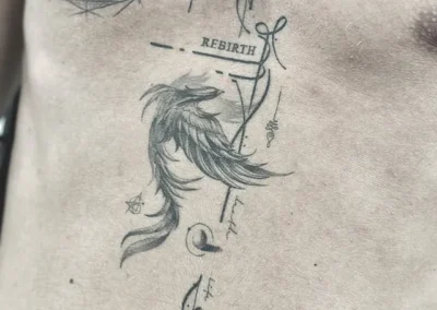Helet tatovering med en føniks, stjerner og ordet rebirth på brystkassen