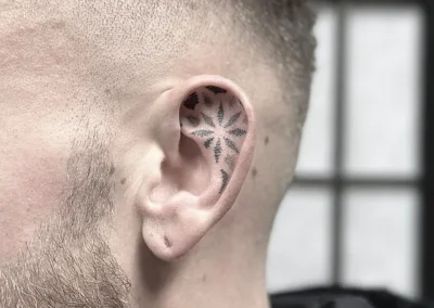 Fineline-tatovering med et stjernemønster inde i øret